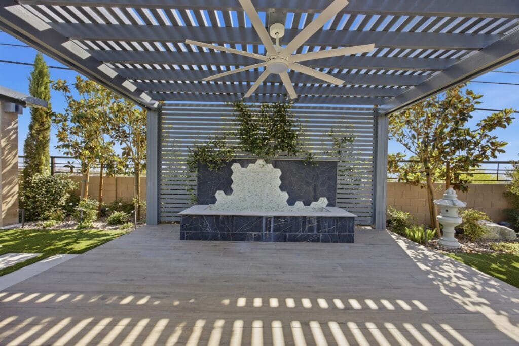 Modern backyard with pergola, water feature, landscaping, and hardscape patio design.